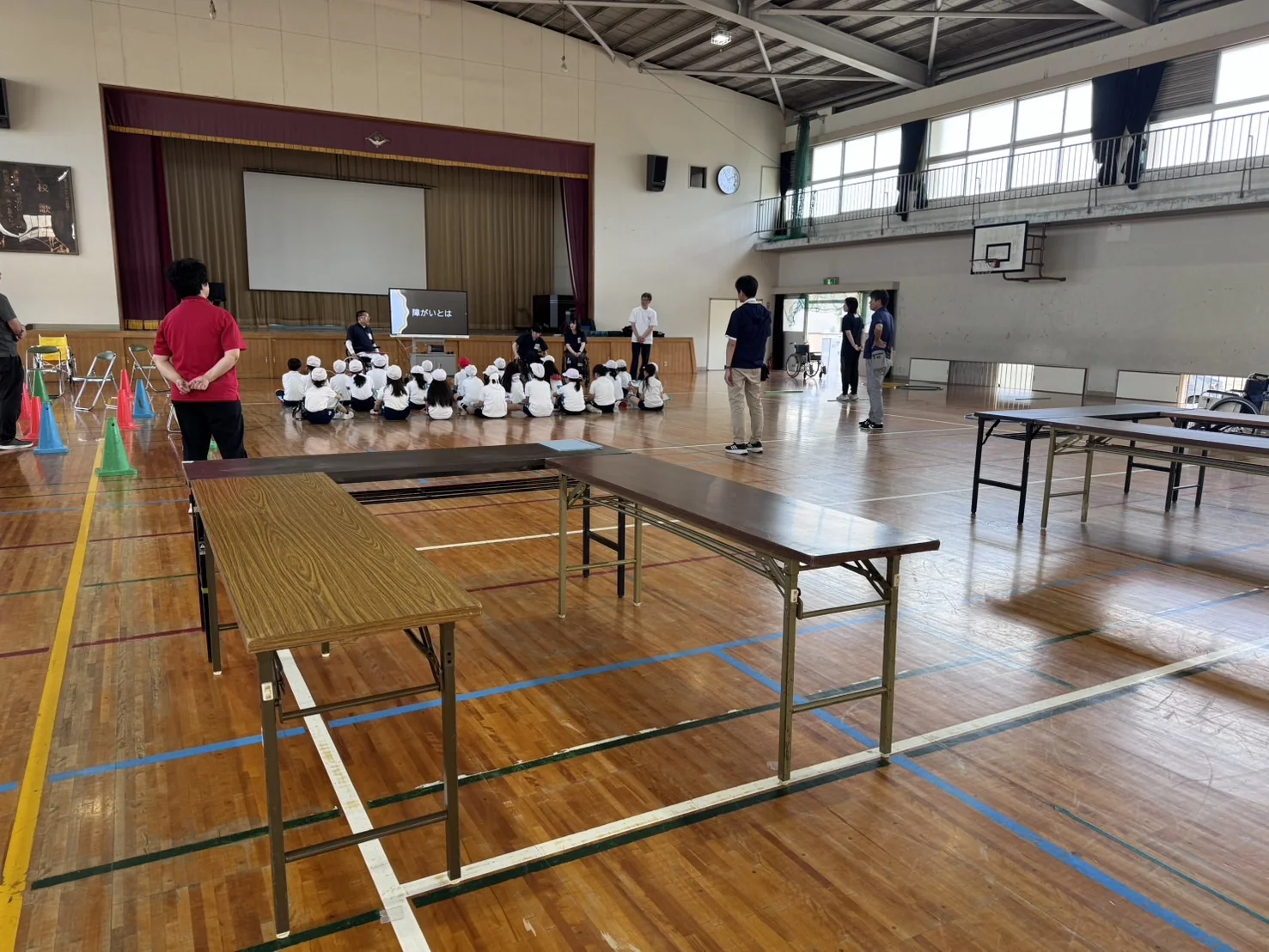 子どもたちが体育館で講演を聞いている様子